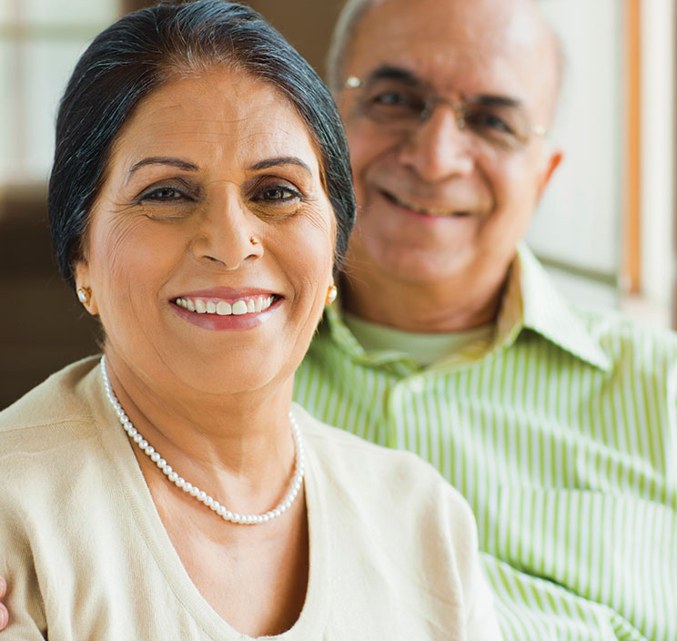 A woman smiling with a man behind her. Links to What to Give A woman smiling with a man behind her. Links to What to Give