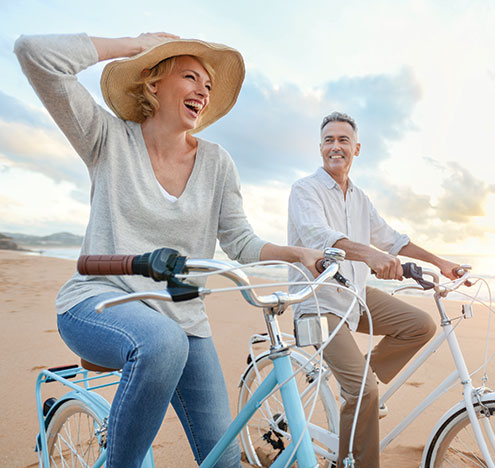 A couple riding bicycles. Links to Gifts of Life Insurance